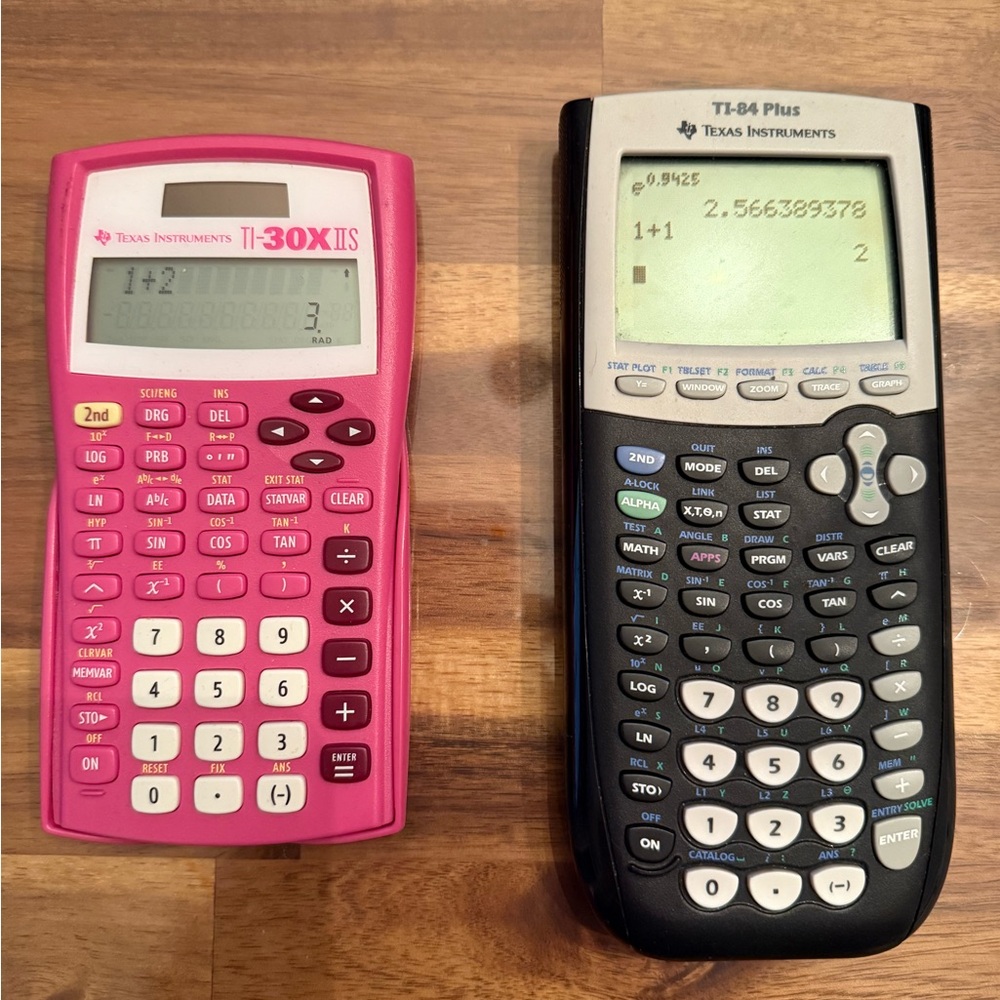 Texas Instruments pink TI-30X IIS and a black TI-84 Plus